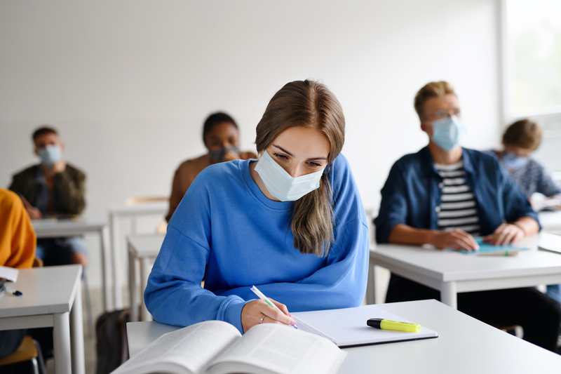 student with mask at desk