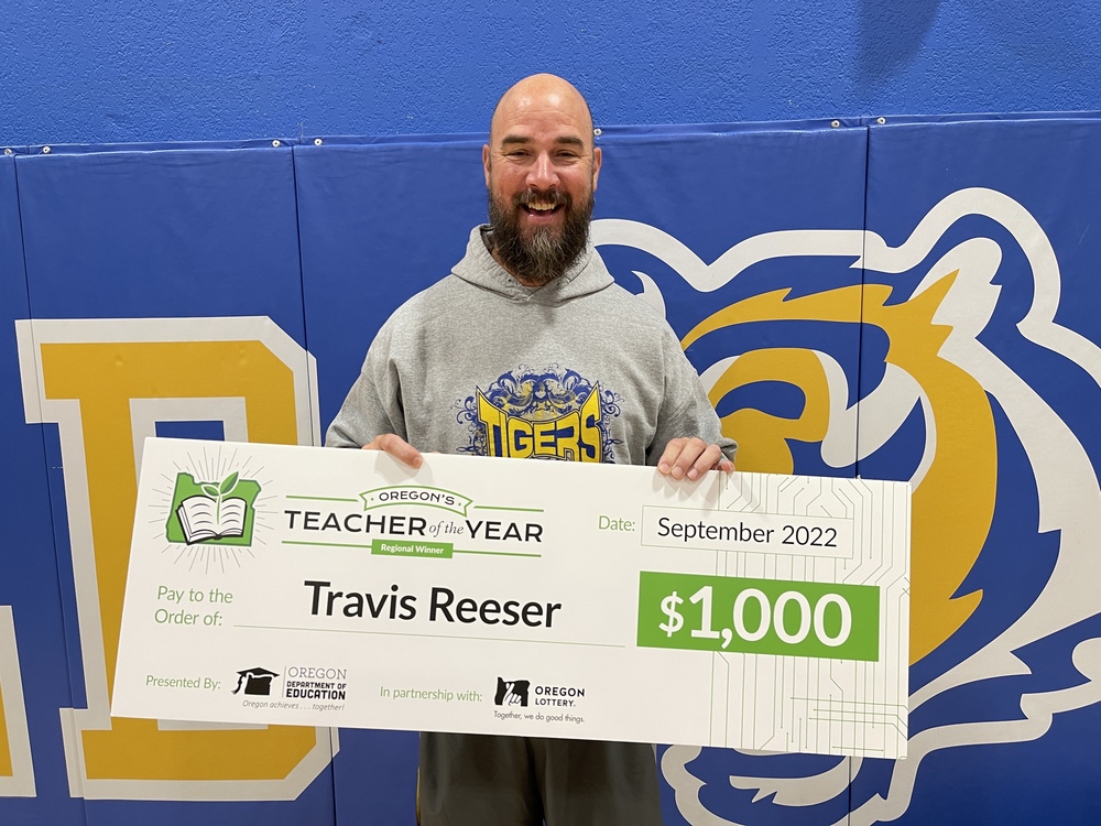 Travis Reeser holds his award check
